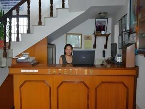 una mujer sentada en un escritorio con una computadora portátil en Hotel Norbu Sangpo, en Katmandú