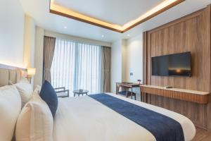 a hotel room with a bed and a flat screen tv at Hotel Sara Sadan in Kathmandu