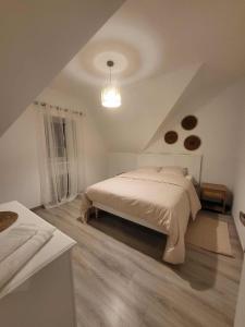 a white bedroom with a bed and a ceiling at Goncalves in Guipavas