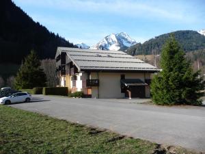 a building with a car parked on the side of a road at Appartement face à la montagne in Abondance