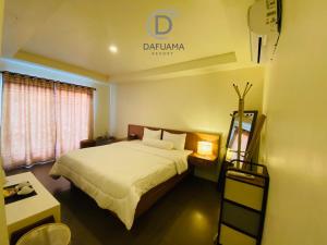 万慈Dafuama Resort的酒店客房,设有一张床,墙上有标志