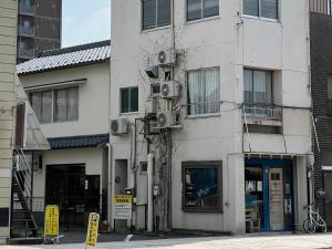 a white building with speakers on the side of it at めくる in Matsumoto