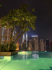 a swimming pool with a city skyline at night at Ubays Majestic House in Kuala Lumpur
