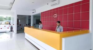 two women standing behind a counter in a room at Amaris Hotel Palangkaraya in Palangkaraya