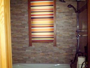 a bathroom with a shower and a bath tub at Agros Timber Log House in Agros