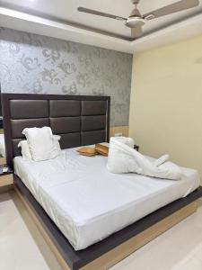 a bedroom with a large bed with white sheets and pillows at Hotel Kalita Palace in Sivasagar
