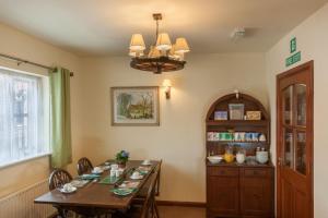 a dining room with a table and a chandelier at Bridge House in Henley in Arden