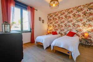 a bedroom with two beds and a large window at Le clos suzette in Bouranton