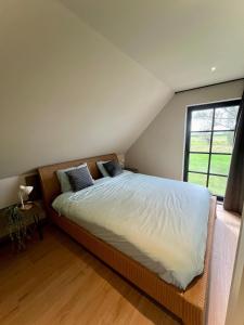a bedroom with a large bed and a window at Green Bliss in Wervik