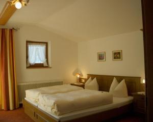 a bedroom with a large white bed with a window at Gästehaus Elfriede in Gerlos