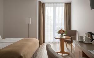 una habitación de hotel con una cama y una mesa con flores en Hotel Chrisma, en Düsseldorf