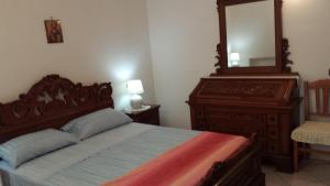 ein Schlafzimmer mit einem Bett mit einer Kommode und einem Spiegel in der Unterkunft Cartaromana House in Ischia