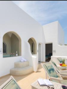 a living room with white walls and a glass table at family love suite in Santorini