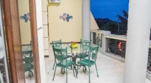 a glass table and chairs on a balcony at OYO 643 Al Thalib 8 Syariah in Malang +145 photos