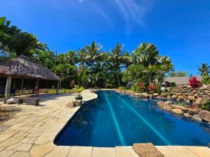 a swimming pool next to a resort with trees at MIRZ Accomodation in Pacific Harbour