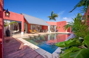 a swimming pool in front of a house at Villa Coco Chic - Piscine privée - Paradis Tropical in Pointe aux Piments