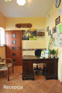 - un bureau avec un bureau en bois dans la chambre dans l'établissement Villa Dom Julii, à Sanok