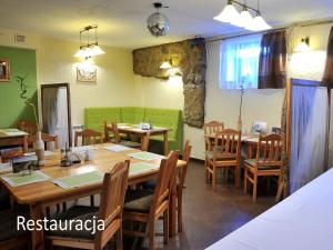 una sala da pranzo con tavoli e sedie in legno di Villa Dom Julii a Sanok