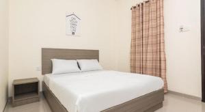 a bedroom with a large bed with white sheets at OYO Life 2735 Graha Nirwana in Nagoya