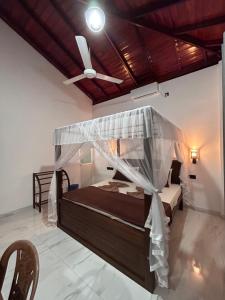 a bedroom with a bed with a ceiling fan at SJ7 Guest House in Mirissa +10 photos