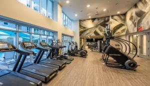 a gym with a row of treadmills and ellipticals at High stay, new furniture apartment in Glendale