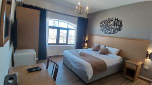 ein Schlafzimmer mit einem Bett und einem Tisch darin in der Unterkunft Moab Land Hotel in Madaba