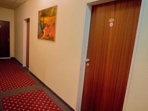 a hallway with a door and a painting on the wall at Hotel Lumen am Hauptbahnhof in Hamburg