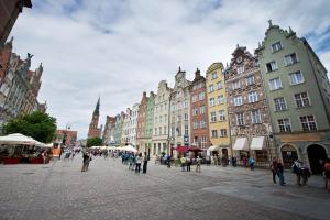 a group of people walking around a street with buildings at YOURAPART Gdańsk Starówka in Gdańsk
