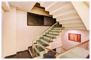 una escalera en una casa con una pintura en la pared en Hotel Magnus Residency Near Railway Station, en Cuttack