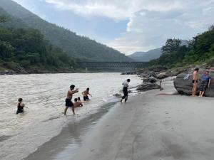 瑞诗凯诗Buddha Retreat in Rishikesh, India的一群人在河上玩耍 更多4张照片