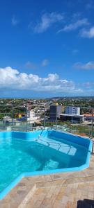 a large blue swimming pool on top of a building at Flat Pérola da Praia in Conde