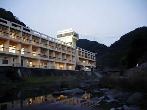 a hotel with a river in front of a building at Hotel Myoken Tanaka Kaikan in Kirishima