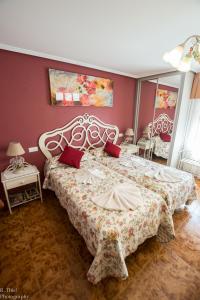 1 dormitorio con 1 cama grande y paredes rojas en Hostal Camino de Santiago, en Frómista