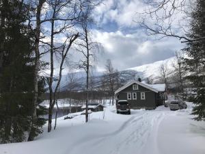 a house in the snow with cars parked in the driveway at 6 person holiday home in Ballangen in Ballangen