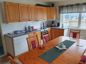 a kitchen with wooden cabinets and a wooden table at 8 person holiday home in Mølnarodden in Sund +25 photos