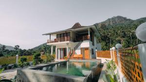 a house with a swimming pool in front of it at Semu Villa - Three Bedroom Private Pool Villa in Pawenang