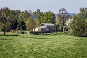 ein Haus inmitten eines großen Grasfeldes in der Unterkunft Bahnwärterhaus in Droßdorf