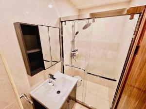 バギオにあるCondotel Near SM Baguio, Cathedral & Session Rd by Le Chateau Baguioの洗面台とシャワー付きのバスルーム