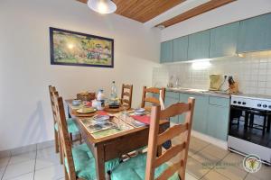 a kitchen with a wooden table and chairs in a room at La horen in Plérin