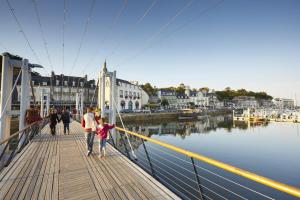 a group of people walking on a dock near the water at La horen in Plérin