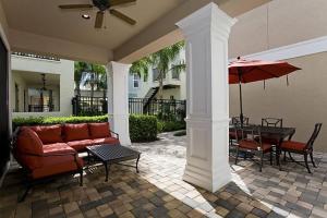 a patio with a couch and a table and an umbrella at Orlando Family Friendly Home in Kissimmee