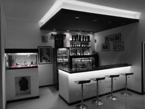 um bar com bancos numa sala com lareira em Bardot Hostel em Paraná