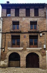 a brick building with two doors and two balconies at Plaza Apartamentos in Binéfar