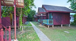 a row of houses with a bench in the yard at OYO 90620 Mahseer Chalet in Kuala Tahan