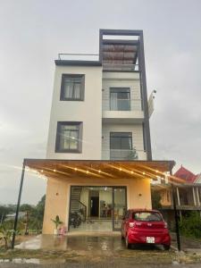 un'auto rossa parcheggiata davanti a un edificio di Moc Mien Seaside Homestay & Coffee Doc Let a Doc Let