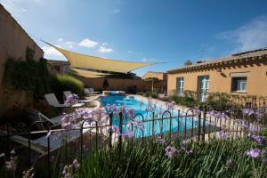 - une piscine dans une cour ornée de fleurs violettes dans l'établissement Aquae Sinis Albergo Diffuso, à Cabras