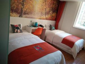 a room with two beds and a painting on the wall at Pai Hotel Yanjiao Tianyang Plaza in Gaolou