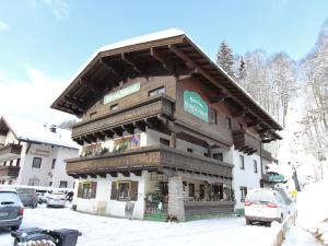 a building in the snow with cars parked around it at Apartment in Saalbach-Hinterglemm near Ski Area in Saalbach Hinterglemm