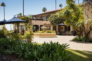 a building with a courtyard with plants and umbrellas at The Milo in Santa Barbara