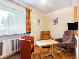 a living room with a table and two chairs and a television at Apartment in Saalbach-Hinterglemm near Ski Area in Saalbach Hinterglemm